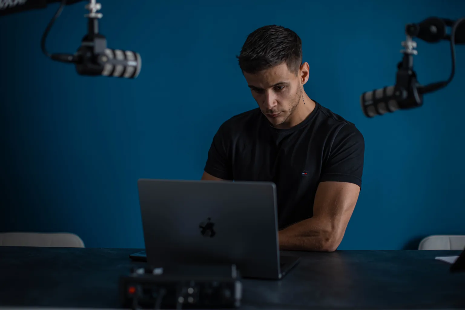 Un membre de l'équipe Influmedia travaille sur un ordinateur portable, dans le studio de l'agence à Orléans